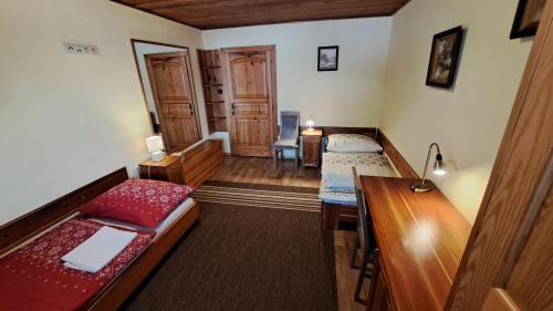 a room with two beds and a desk in a room at Privát Nataša in Nová Lesná