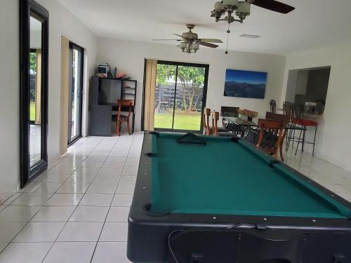 a living room with a pool table in it at Cozy family home in quiet area, nice garden views. in Tamiami