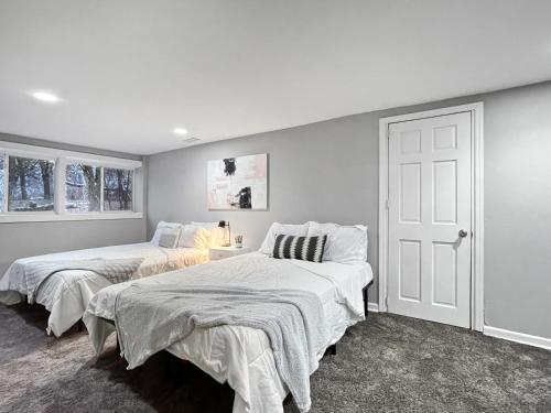 - 2 lits dans une chambre aux murs blancs dans l'établissement Roomy 4br By Drake Sleeps 13 Huge Yard, à Des Moines