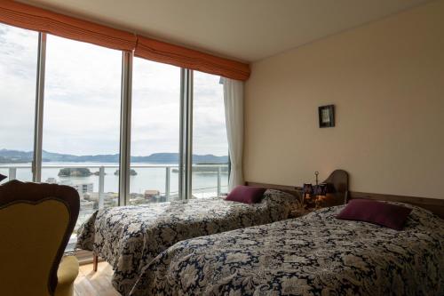 two beds in a room with a large window at La Classe Angel Road 2 - Vacation STAY 71507v in Fuchisaki