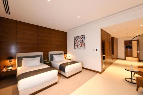 a hotel room with two beds and a table at Golden Tulip Riyadh Convention and Exhibition Center in Riyadh