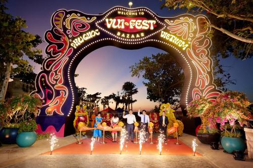 a group of people standing under an arch at a carnival at Mellon OASIS Phu Quoc in Phu Quoc