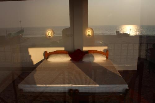 Marari Sunset Beach Villa في أليبي: سرير في غرفة مطلة على المحيط