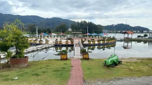 a marina with a green boat in the water at Laguna Apartment 2, Marina Island Homestay in Kampong Batu Gajah