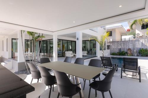 an open dining room with a table and chairs at Stunning villa with pool and tropical garden in Hua Hin