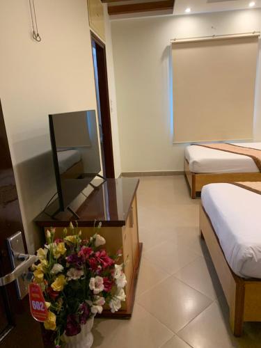 a hotel room with a mirror and a vase of flowers at Hotel Love - 315 Đ. Hoàng Mai - by Bay Luxury in Hanoi