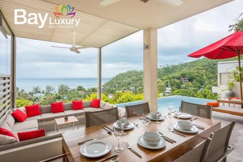 a dining room with a table and a view of the ocean at Luxury Asian Flair Villa in Koh Phangan