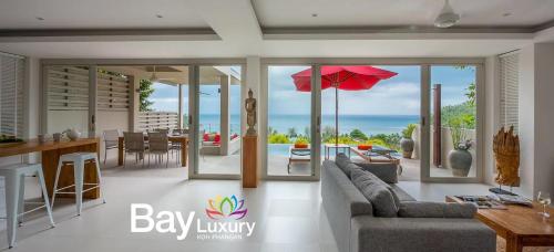 a living room with a couch and a table with an umbrella at Luxury Asian Flair Villa in Koh Phangan
