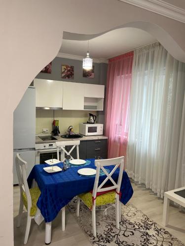 eine Küche mit einem Tisch und einem blauen Tischtuch in der Unterkunft Апартаменты в центре Астаны in Astana