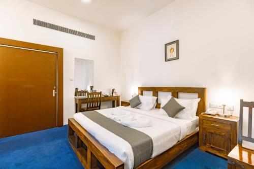 1 dormitorio con 1 cama grande y alfombra azul en Hotel Narendra Central, en Mūvattupula