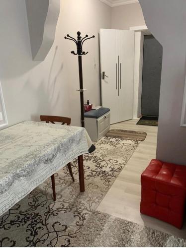 Zimmer mit einem Tisch, einem Stuhl und einer Tür in der Unterkunft Апартаменты в центре Астаны in Astana