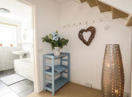 a bathroom with a blue shelf with a heart on the wall at 27 Cae Du in Abersoch