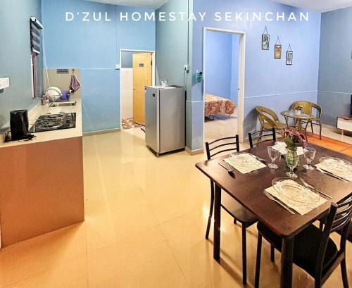 eine Küche und ein Esszimmer mit einem Tisch und einem Kühlschrank in der Unterkunft 3-4paxs Sekinchan Dzulhomestasy Padi View Aircon in Kampong Batu Dua Puloh Tiga