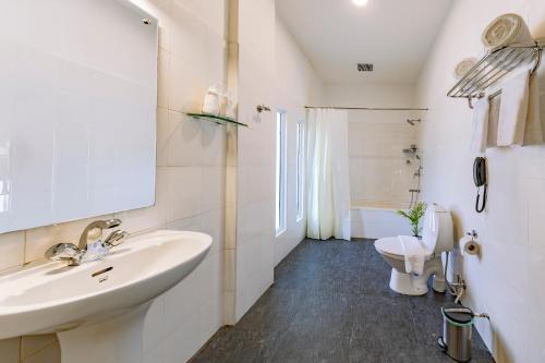 y baño con lavabo y aseo. en Hotel Narendra Central, en Mūvattupula