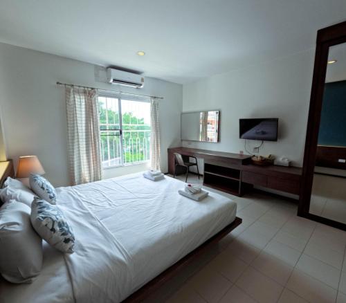 ラノーンにあるLe Ranong Bistro Hotelの大きな白いベッドとテレビのある寝室