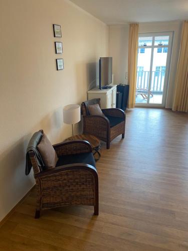 a living room with two chairs and a television at Haus Strandeck Apartment Meeresrauschen 10 in Göhren