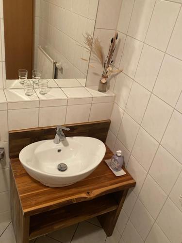 a bathroom with a sink and a mirror and glasses at Haus Strandeck Apartment Meeresrauschen 10 in Göhren