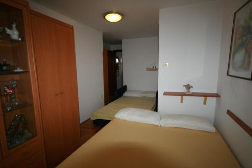 Habitación pequeña con 2 camas y armario. en Apartment Ana, en Crikvenica