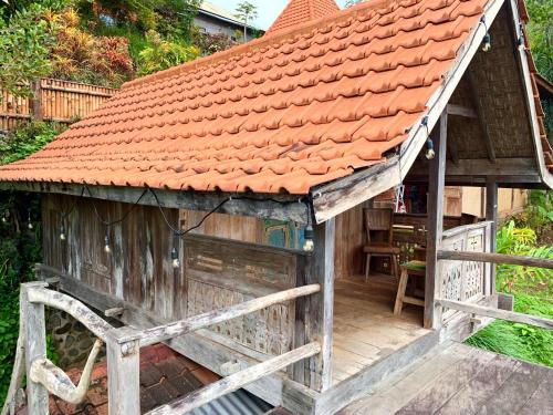 a small wooden house with an orange roof at Villa Kepuh in Singaraja