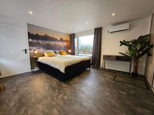 een slaapkamer met een bed met een schilderij aan de muur bij Luxe woonboot in de natuur evt met console bootje! in Leeuwarden