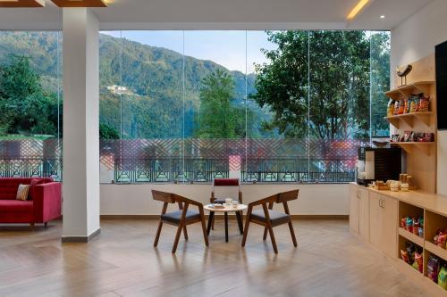 a dining room with a table and chairs and a large window at Ginger Gangtok in Gangtok