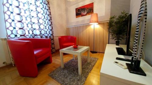 a living room with a red chair and a table at Atos in Novi Beograd