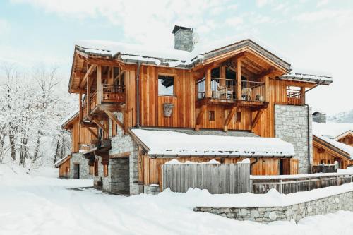 une maison en rondins dans la neige dans l'établissement Joubarbe Rose by Lodji, à Saint-Martin-de-Belleville