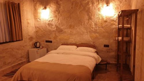 1 Schlafzimmer mit 2 Betten in einer Steinwand in der Unterkunft Ceran Stone House in Nevşehir