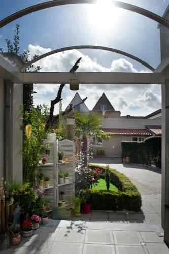 ogród z roślinami i ptakiem siedzącym na patio w obiekcie Central Bruges B&B w Brugii
