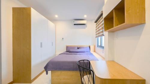 a small bedroom with a bed and a table at Lucy House in Ho Chi Minh City