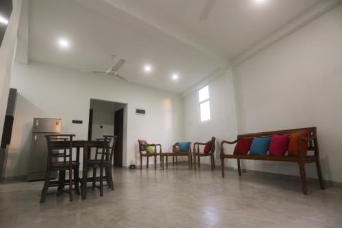 a room with chairs and a table and a couch at cric villa in Galle