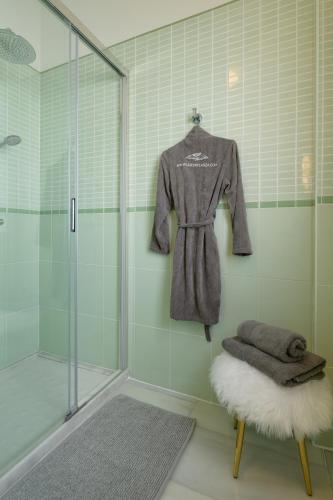 a bathroom with a shower and a robe at Oasis de lujo - luxury boutique villa in Costa Teguise