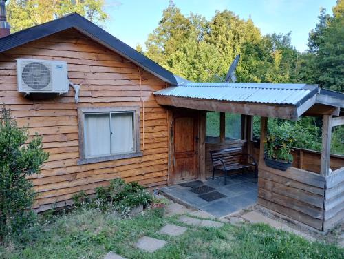 a log cabin with a porch and a air conditioner at Cabaña en parcela a 5 minutos de Valdivia in Valdivia
