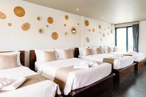 a hotel room with three beds with white sheets at Baan Tah On The Sea in Bang Sare