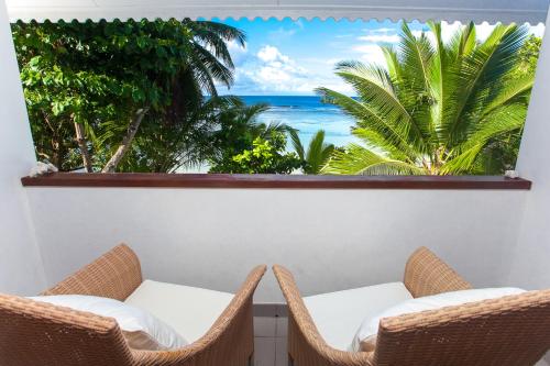 a balcony with chairs and a view of the ocean at La Belle Tortue in Silhouette Island