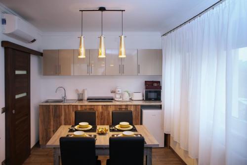 a kitchen with a wooden table and a dining room at PRÉMIUM APARTMANOK in Kisvárda
