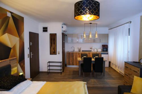 Habitación con cama y cocina con mesa en PRÉMIUM APARTMANOK en Kisvárda