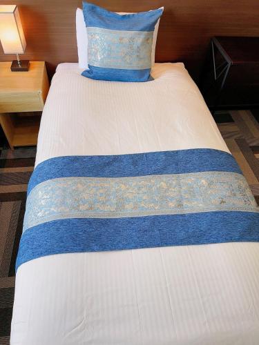 łóżko w pokoju z niebieską poduszką w obiekcie Ogaki Hiyori Hotel - Vacation STAY 08651v w mieście Ogaki
