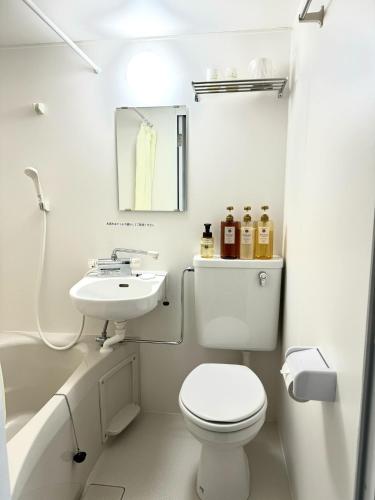 Baño blanco con aseo y lavamanos en Ogaki Hiyori Hotel - Vacation STAY 08651v en Ogaki