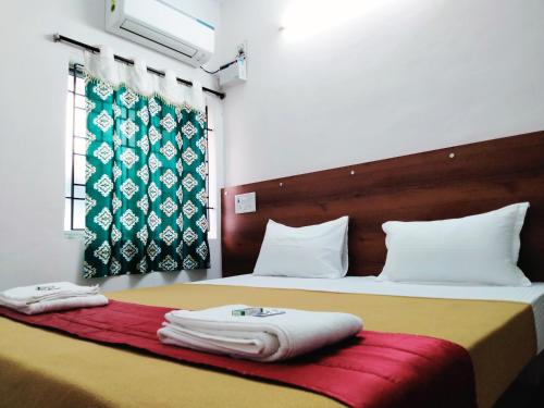 a hotel room with two beds with towels on them at Hotel Royal Green Inn in Chennai
