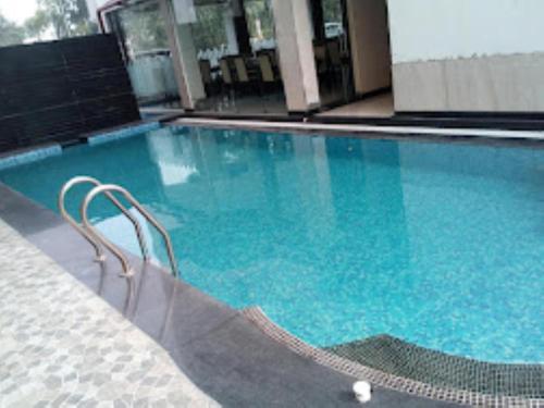 una piscina de agua azul en un edificio en Airport Guest House Guwahati en Guwahati