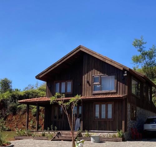 ein Holzhaus mit einem davor geparkt in der Unterkunft Olive Cottage Bao Loc in Tang Jran Dring