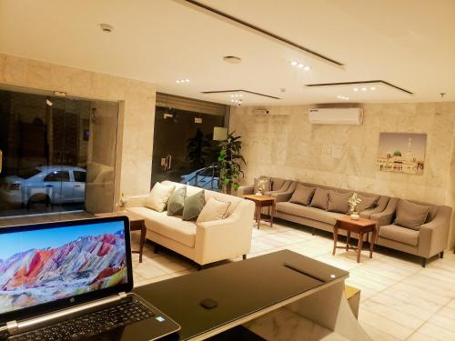 a living room with a laptop computer on a table at فندق اسكان وافر متوفر توصيل مجاني للحرم على مدار 24 ساعة in Makkah