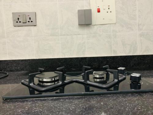 a gas stove top in a kitchen next to a wall at Iyoba Apartment in Abuja