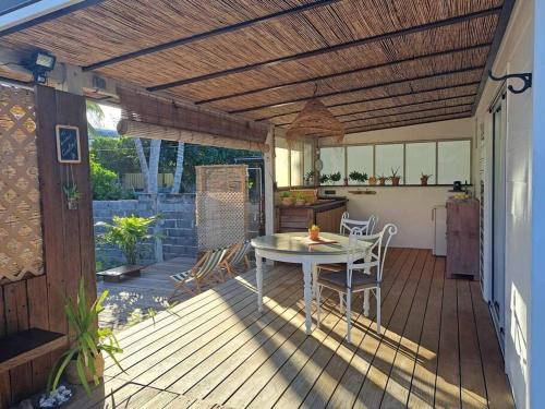 a wooden patio with a table and a kitchen at Breeze Ocean Bungalow Moorea in Moorea