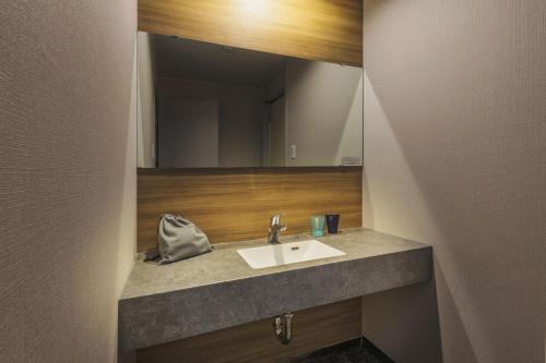 a bathroom with a sink and a mirror at Takamiya Hotel Jurin in Zao Onsen