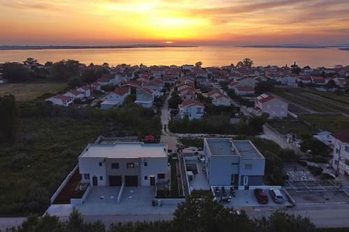 eine Luftansicht einer Stadt mit Sonnenuntergang im Hintergrund in der Unterkunft Villa Tri Palme with heated pool in Vrsi