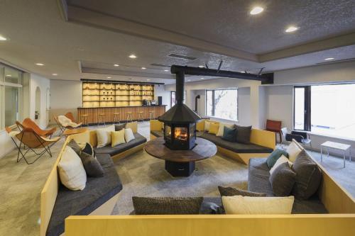 a living room with couches and a fireplace at Takamiya Hotel Jurin in Zao Onsen