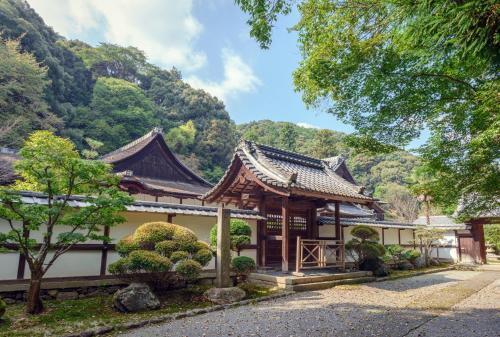 a house with a mountain in the background at Temple-stay WAQOO Mii-dera in Otsu