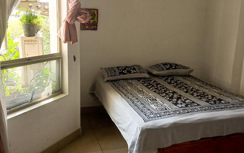 Bett in einem Zimmer neben einem Fenster in der Unterkunft Mount View Residencies in Colombo